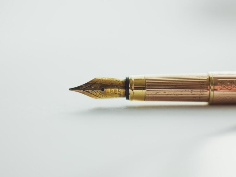Concepto 015661 del 07-09-2026. Procedimiento. Firma del revisor fiscal en declaraciones y correcciones. 10 Pluma estilográfica dorada sobre superficie blanca