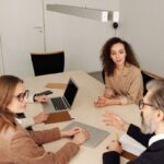 Oficio 016677 del 23-09-2026. Renta. Asociación gremial sin ánimo de lucro de importadores, exportadores y transportadores como entidad no contribuyente. Equipo de trabajo reunido alrededor de una mesa en una oficina moderna