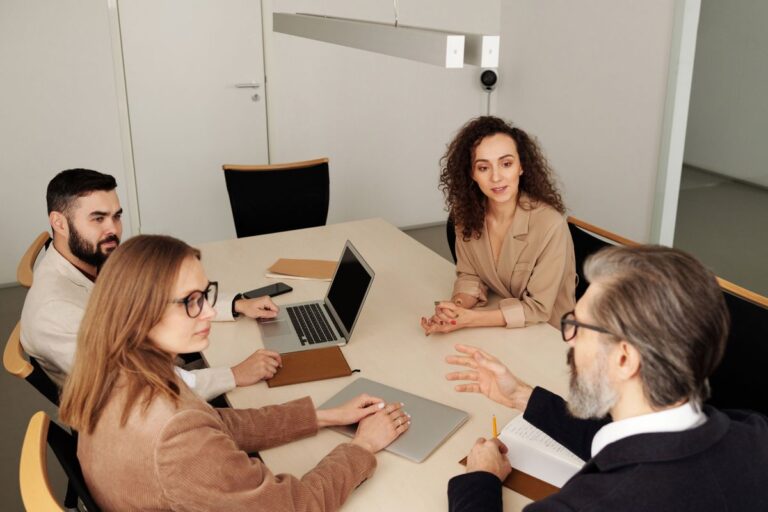 Oficio 016677 del 23-09-2026. Renta. Asociación gremial sin ánimo de lucro de importadores, exportadores y transportadores como entidad no contribuyente. 7 Equipo de trabajo reunido alrededor de una mesa en una oficina moderna