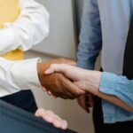 Colegas de distintos orígenes se dan la mano en una reunión de trabajo