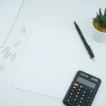 Calculadora negra y bolígrafo sobre papel