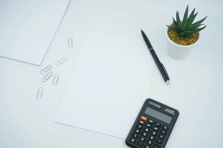 Calculadora negra y bolígrafo sobre papel