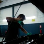 Mecánico revisa el nivel de aceite del motor de un vehículo en un taller