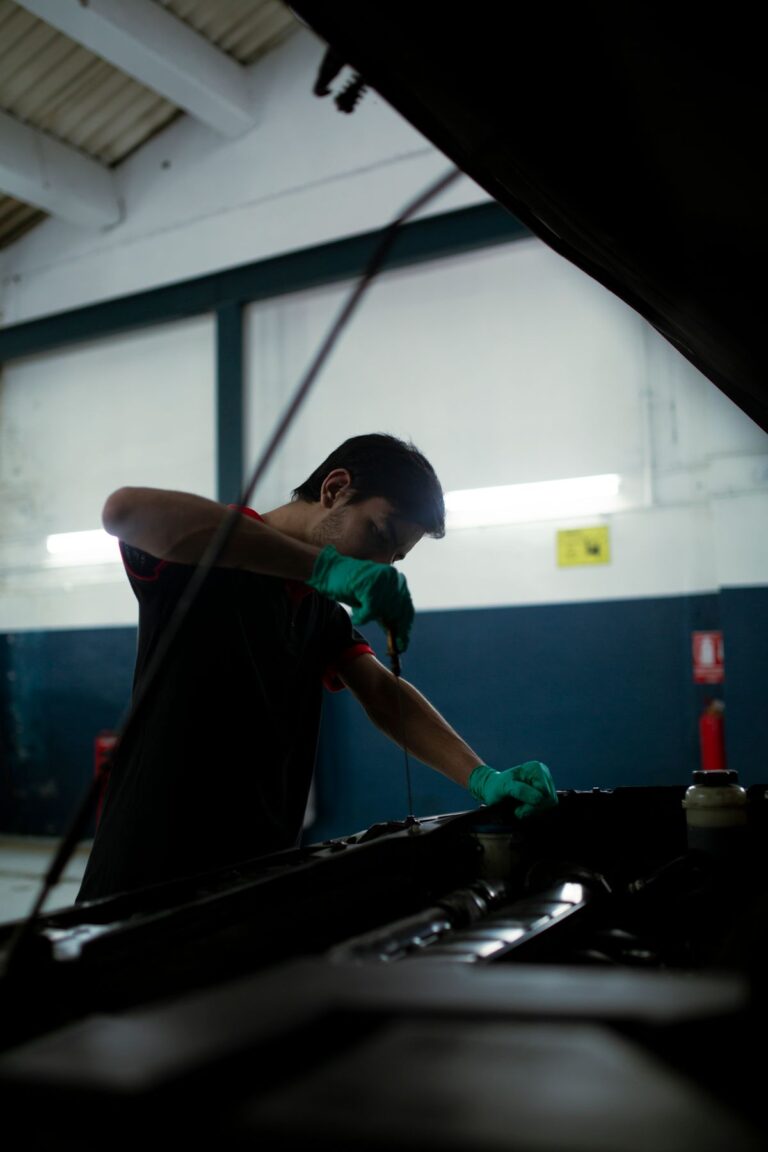 Mecánico revisa el nivel de aceite del motor de un vehículo en un taller