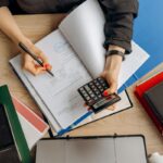Sentencia 28665 del 18-06-2026. Procedimiento. Sanción por irregularidades en la contabilidad por diferencias entre los libros y la declaración de IVA. Contadora analizando documentos financieros con una calculadora