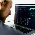 Concepto 016671 del 18-09-2026. Renta. Pérdidas en la enajenación de participaciones en ETF constituidos en el exterior por personas naturales residentes. Hombre analiza datos de inversiones en la pantalla de su computador