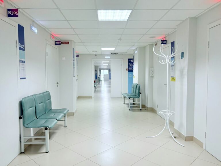 Pasillo de hospital vacío con bancas y puertas