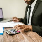 Concepto DAF 050674 del 14-07-2026. Territorial. Procedimiento. Títulos de depósito judicial de procesos de cobro coactivo terminados o prescritos. Profesional revisando documentos financieros con una calculadora