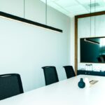 Sala de juntas con mesa blanca y sillas negras