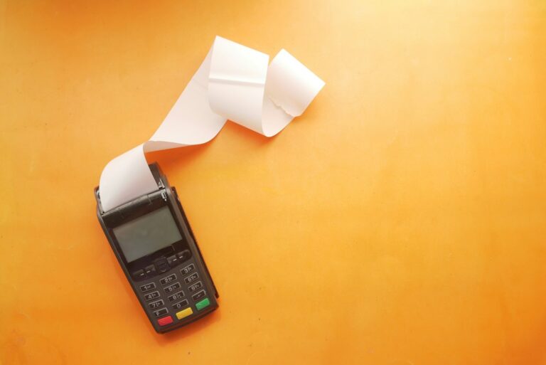 Concepto 015505 del 04-09-2026. Régimen SIMPLE. Descuento de aportes a pensiones y de pagos electrónicos. 3 Datáfono con recibo sobre fondo naranja